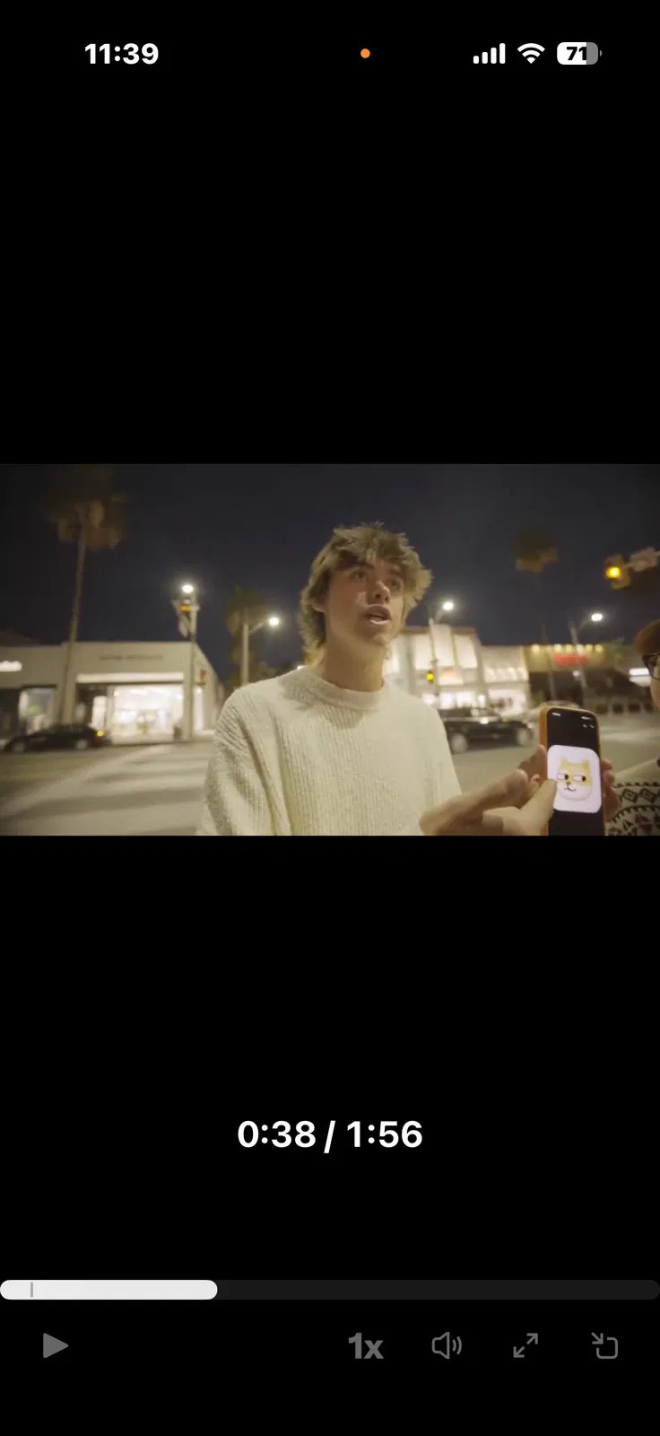 A person showing the Wangchai dog meme on a phone during a street encounter
